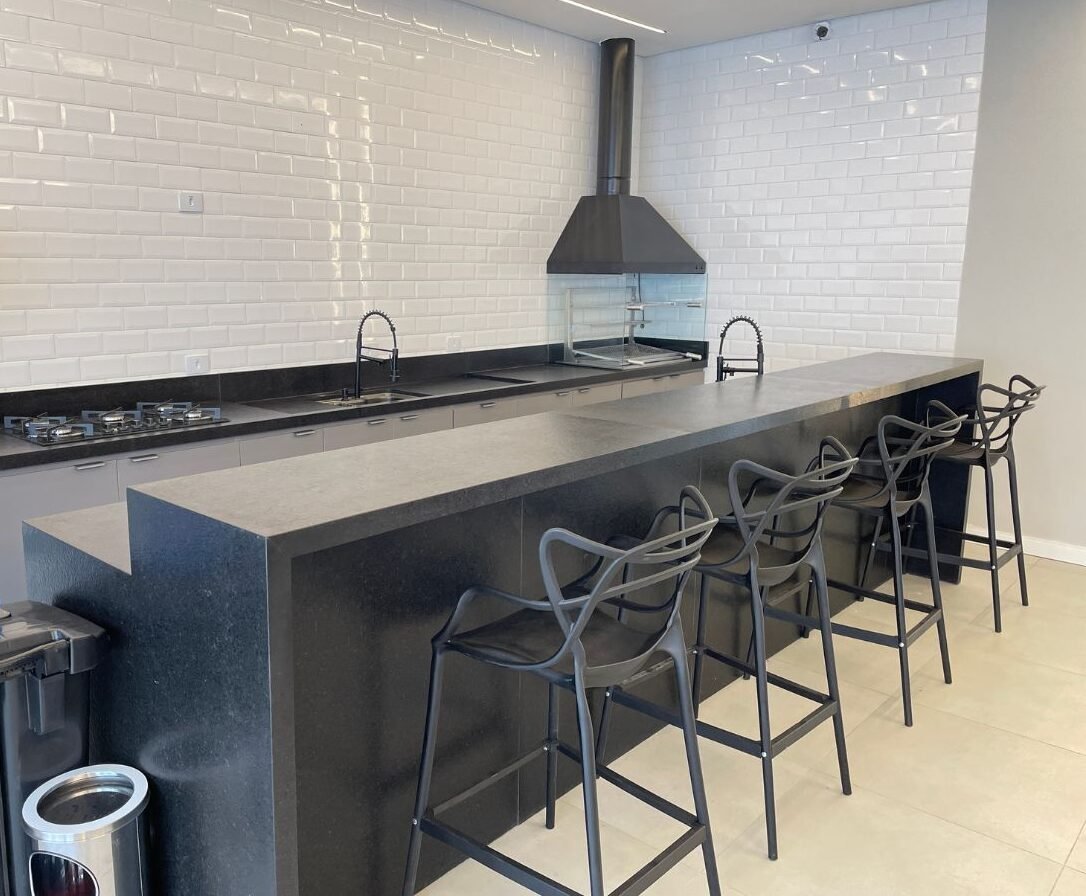 Espaço gourmet com balcão, banquetas e churrasqueira embutida no Spasie, São Paulo