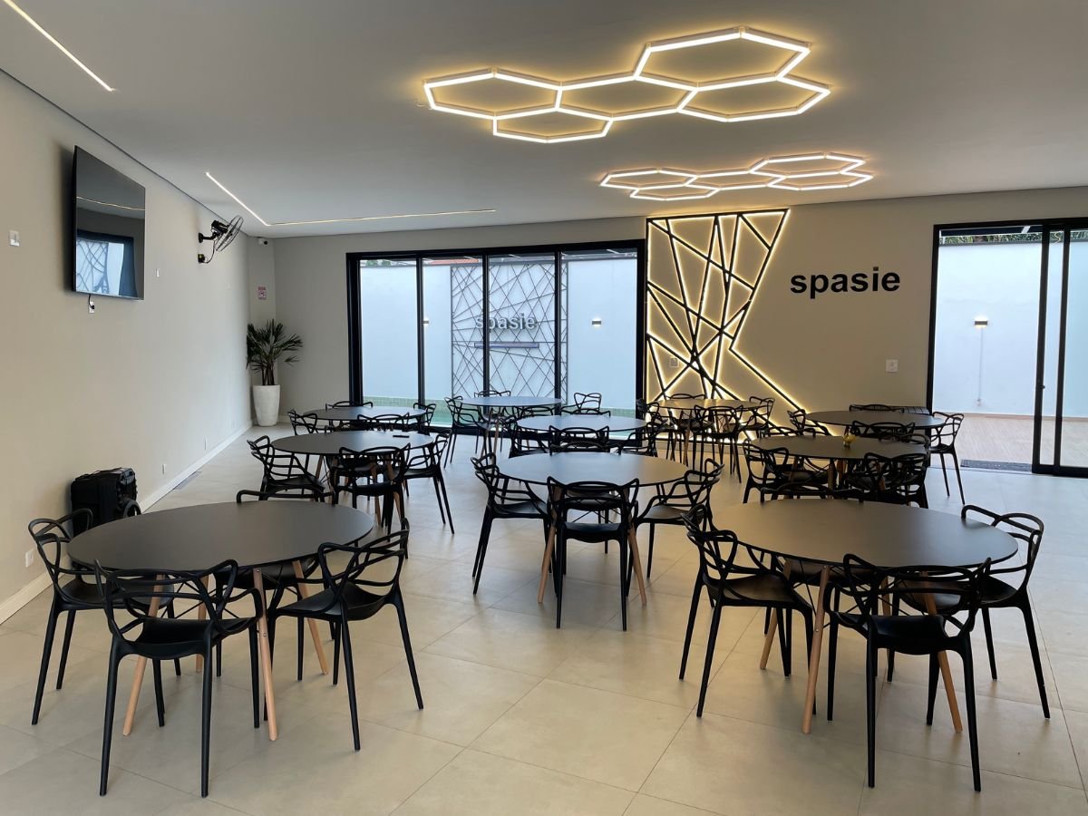 Salão principal montado com mesas e iluminação hexagonal no Spasie, espaço para eventos em São Paulo